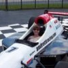 Maria in driver's seat of race car